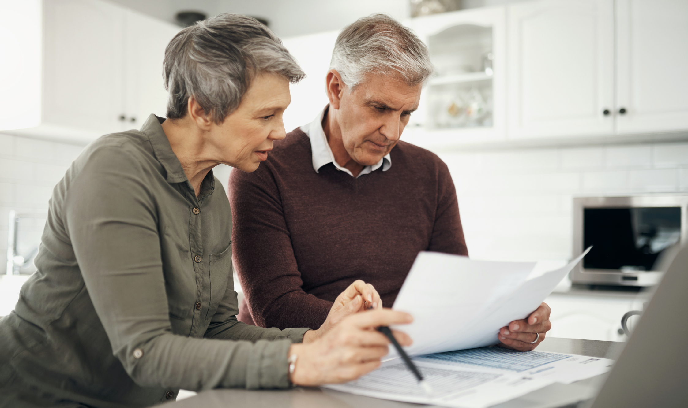 Laptop, documents for finance with a senior couple at a table in their home together for retirement planning. Computer, investment or budget with an elderly husband and wife accounting for the future